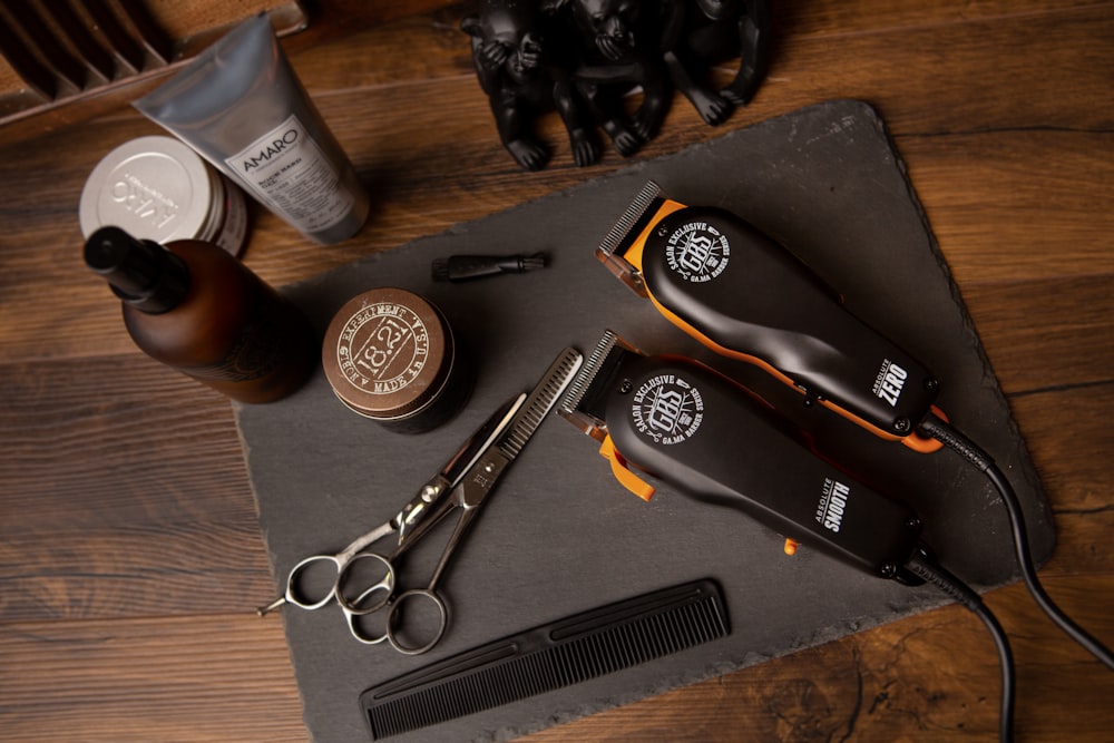 Hair clippers, scissors, and tools on a slate mat